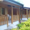 Veranda di bungalow in legno con sedie bianche.