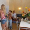 Famiglia in cucina. Donna cucina, bambino ride, uomo seduto.