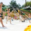 Persone giocano con spruzzi d'acqua vicino a un tema navale.